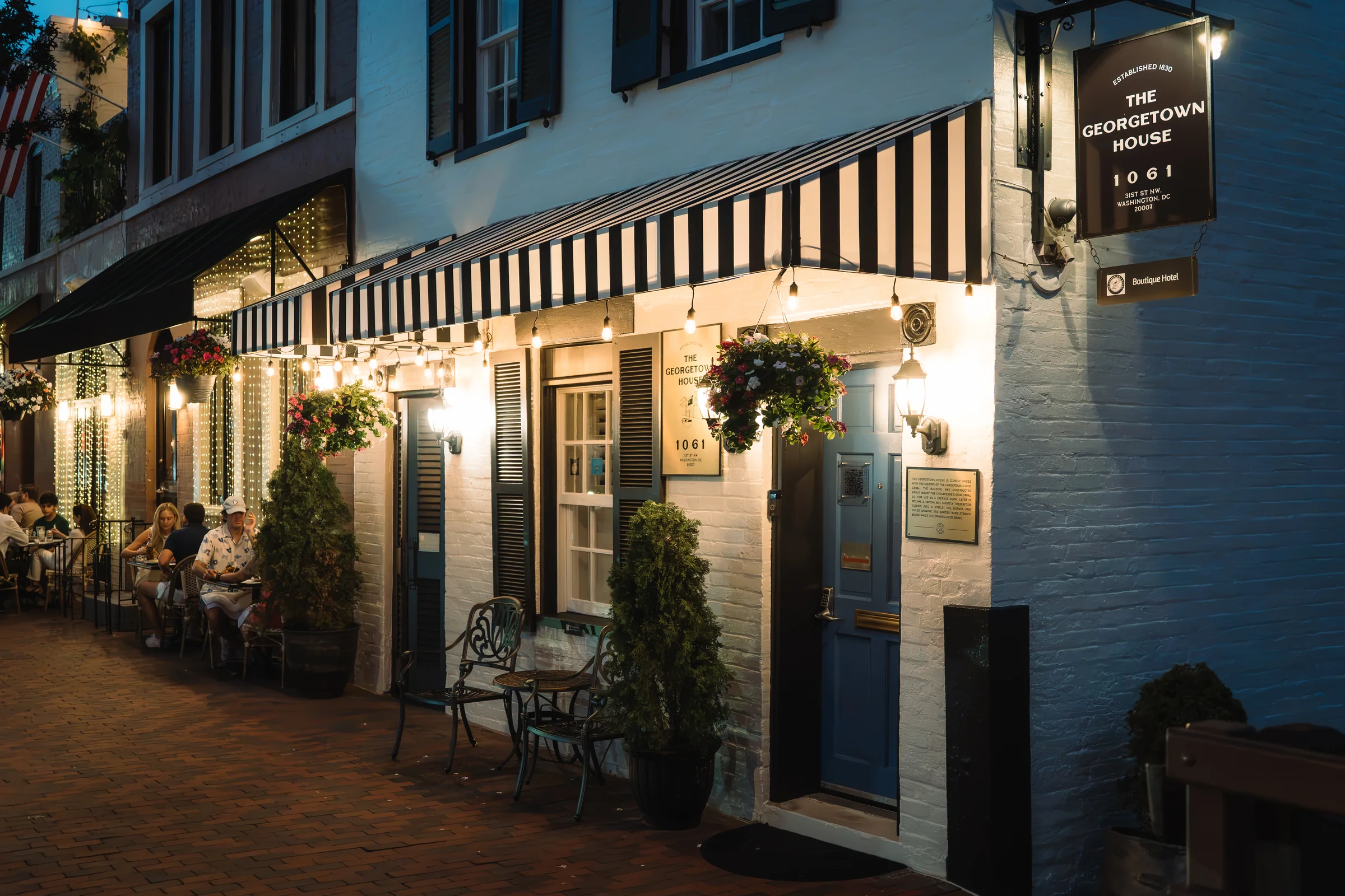 A grand, historic brick exterior of a boutique hotel in Georgetown, DC, captured during the soft golden hour.